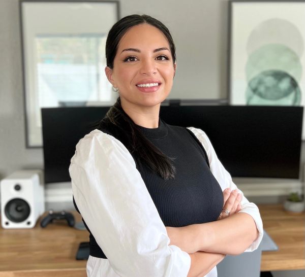 Confident woman smiling with arms crossed in a modern office — Kattie Valle, CPC, Billing Department at Flourish Counseling